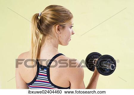 Young woman during strength training with dumbbells View Large Photo Image Stock Image - Young woman during strength training with dumbbells. Fotosearch