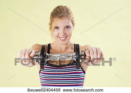 Young woman during strength training with dumbbells View Large Photo Image Stock Photo - Young woman during strength training with dumbbells. Fotosearch