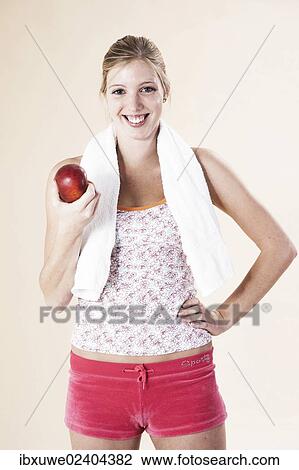 Young woman eating an apple after a workout View Large Photo Image Stock Image - Young woman eating an apple after a workout. Fotosearch
