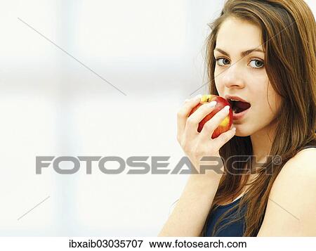Young woman eating an apple View Large Photo Image Stock Photo - Young woman eating an apple. Fotosearch