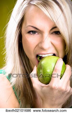 Stock Photograph - Young woman eating an apple. Fotosearch