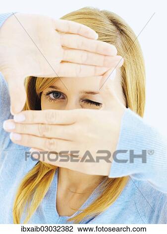 Young woman forming a frame around her eyes with her hands View Large Photo Image Stock Image - Young woman forming a frame around her eyes with her hands. Fotosearch