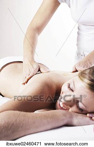 Young woman having her back massaged by a therapist View Large Photo Image Stock Image - Young woman having her back massaged by a therapist. Fotosearch