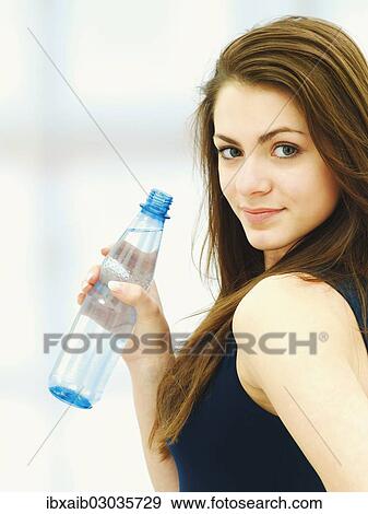Stock Photo - Young woman holding a bottle of water. Fotosearch