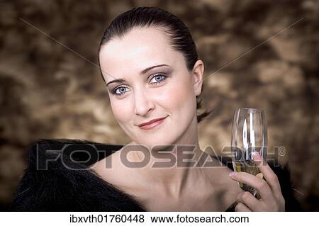 "Young woman holding a champagne glass, portrait" View Large Photo Image Stock Photo - "Young woman holding a champagne glass, portrait". Fotosearch