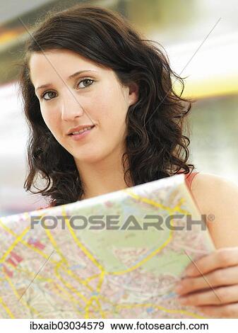 Young woman holding a city map View Large Photo Image Stock Photo - Young woman holding a city map. Fotosearch