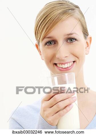 Young woman holding a glass of milk View Large Photo Image Stock Photograph - Young woman holding a glass of milk. Fotosearch