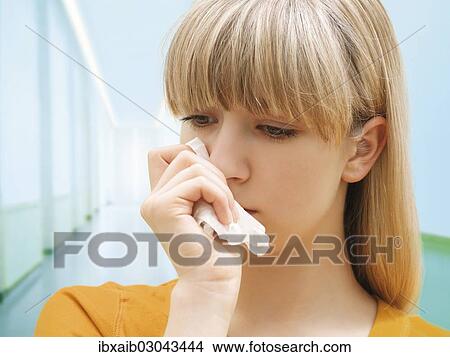 "Young woman holding a tissue, ill, allergy, sad" View Large Photo Image Picture - "Young woman holding a tissue, ill, allergy, sad". Fotosearch