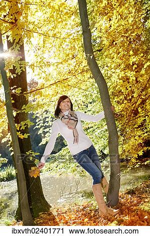 "Young woman holding autumn leaves, in autumnal park" View Large Photo Image Stock Image - "Young woman holding autumn leaves, in autumnal park". Fotosearch