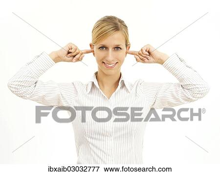Stock Photo - Young woman holding her fingers in her ears. Fotosearch