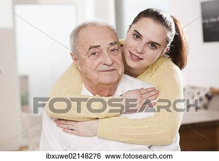 Stock Photograph - Young woman hugging an elderly man. Fotosearch