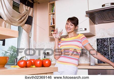 Stock Photograph - Young woman in a kitchen. Fotosearch