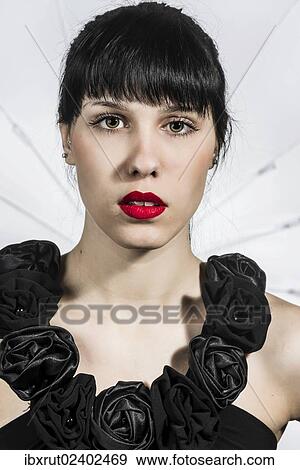Stock Photo - "Young woman in black dress with fabric roses, portrait". Fotosearch