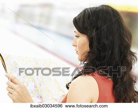 Stock Photograph - Young woman looking at a city map. Fotosearch