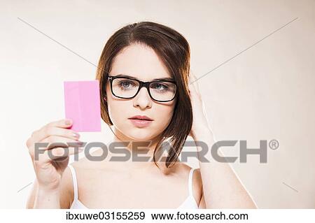 Stock Photo - "Young woman looking at herself in a cosmetic mirror, Mannheim, Baden-Wurttemberg, Germany, Europe". Fotosearch