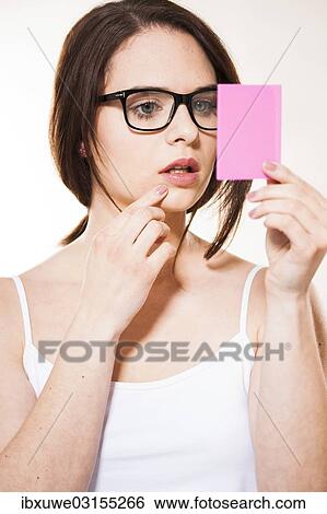 Stock Photograph - "Young woman looking at herself in a cosmetic mirror, Mannheim, Baden-Wurttemberg, Germany, Europe". Fotosearch