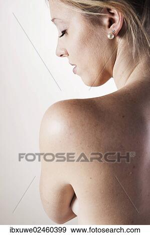 Stock Photo - Young woman looking over her bare shoulder. Fotosearch
