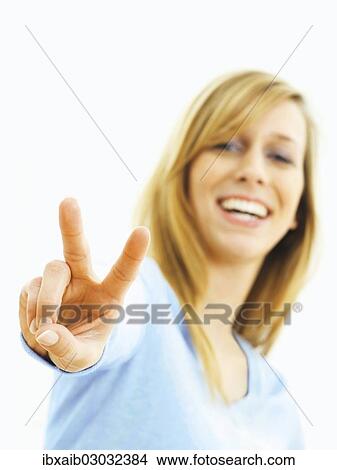 Picture - Young woman making a V for victory sign. Fotosearch