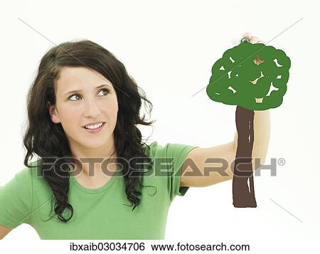 Stock Photograph - Young woman painting a tree. Fotosearch