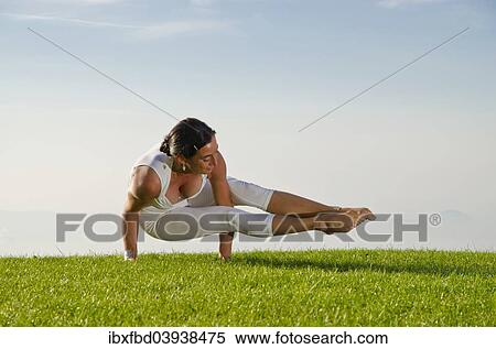 Stock Photography - "Young woman practising Hatha yoga, here the pose kakasana, bakasana, dvi-pada-koundinyasana, variation of the crow pose". Fotosearch