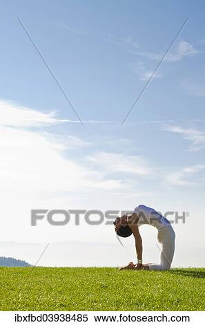 Stock Photography - "Young woman practising Hatha yoga, here the pose ushtrasana, camel pose". Fotosearch