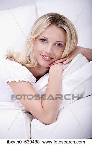 Stock Photo - Young woman reading a book on the sofa. Fotosearch