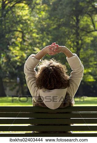 "Young woman relaxing in a park, sitting on a bench, Berlin, Germany, Europe" View Large Photo Image Picture - "Young woman relaxing in a park, sitting on a bench, Berlin, Germany, Europe". Fotosearch