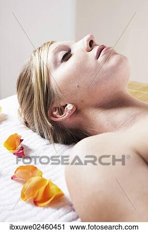 Stock Image - Young woman relaxing on her back. Fotosearch