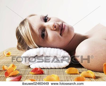 Stock Photo - Young woman relaxing while lying on her back. Fotosearch