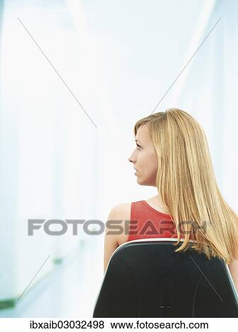 "Young woman sitting on a chair, rear view" View Large Photo Image Stock Photo - "Young woman sitting on a chair, rear view". Fotosearch
