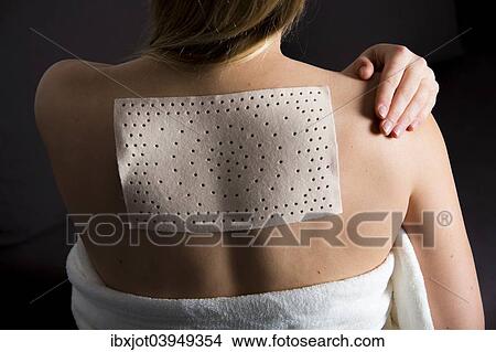 Young woman suffering from back pain has applied a heat plaster View Large Photo Image Picture - Young woman suffering from back pain has applied a heat plaster. Fotosearch