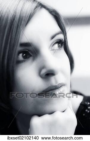 Stock Image - "Young woman supporting her chin on her hand, portrait". Fotosearch
