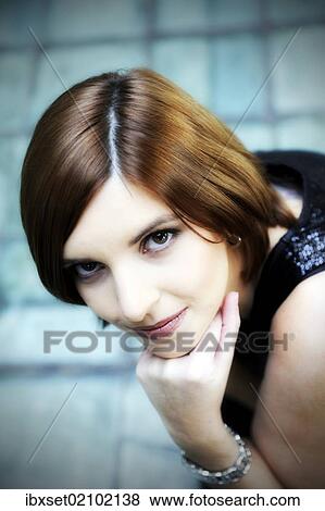Stock Photo - "Young woman supporting her chin on her hand, portrait". Fotosearch