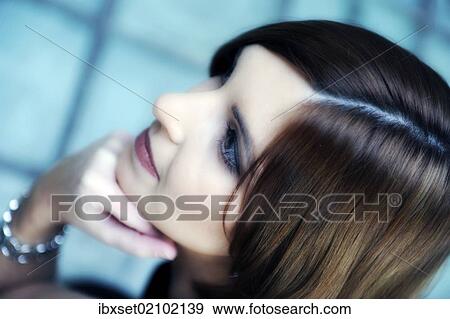 Stock Photo - "Young woman supporting her chin on her hand, portrait". Fotosearch