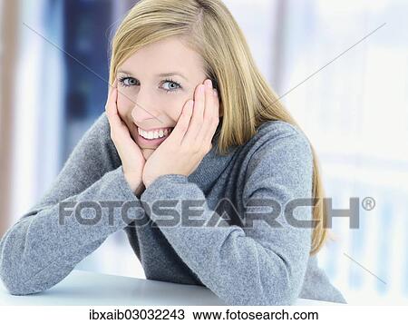 "Young woman, supporting her head in her hands, smiling" View Large Photo Image Stock Image - "Young woman, supporting her head in her hands, smiling". Fotosearch