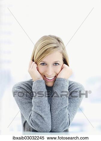 "Young woman, supporting her head in her hands, smiling" View Large Photo Image Stock Photography - "Young woman, supporting her head in her hands, smiling". Fotosearch