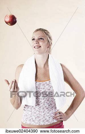 Young woman tossing up an apple after a workout View Large Photo Image Stock Image - Young woman tossing up an apple after a workout. Fotosearch