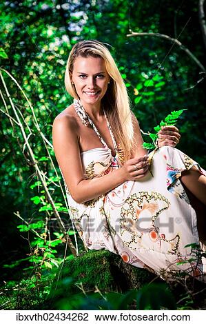 "Young woman wearing a summer dress, in the forest" View Large Photo Image Stock Image - "Young woman wearing a summer dress, in the forest". Fotosearch