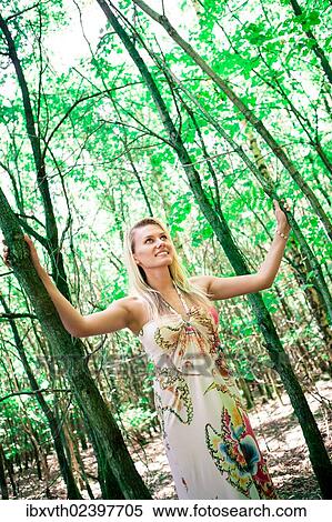 "Young woman wearing a summer dress, in the forest" View Large Photo Image Stock Photography - "Young woman wearing a summer dress, in the forest". Fotosearch