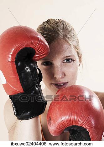 Young woman wearing boxing gloves during boxing training View Large Photo Image Stock Photo - Young woman wearing boxing gloves during boxing training. Fotosearch