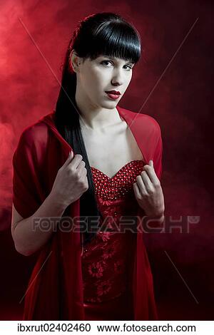 Stock Image - Young woman with long black hair in a red dress. Fotosearch