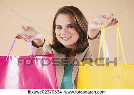 Picture - Young woman with shopping bags while shopping. Fotosearch
