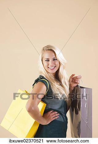 Young woman with shopping bags while shopping View Large Photo Image Stock Image - Young woman with shopping bags while shopping. Fotosearch
