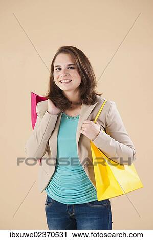 Young woman with shopping bags while shopping View Large Photo Image Stock Image - Young woman with shopping bags while shopping. Fotosearch