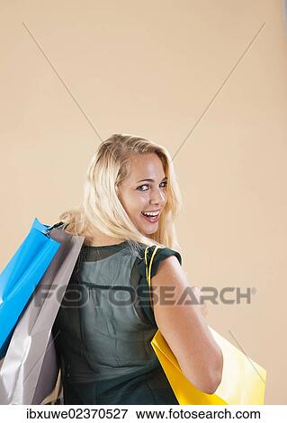 Young woman with shopping bags while shopping View Large Photo Image Stock Photo - Young woman with shopping bags while shopping. Fotosearch