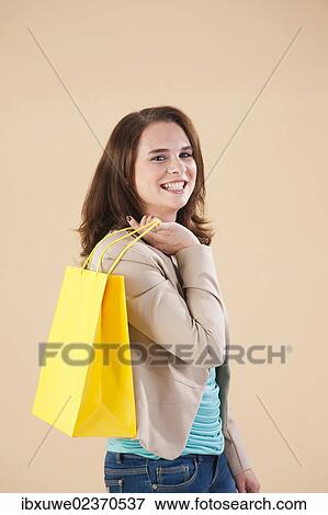 Young woman with shopping bags while shopping View Large Photo Image Stock Photo - Young woman with shopping bags while shopping. Fotosearch