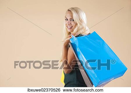 Young woman with shopping bags while shopping View Large Photo Image Stock Photograph - Young woman with shopping bags while shopping. Fotosearch