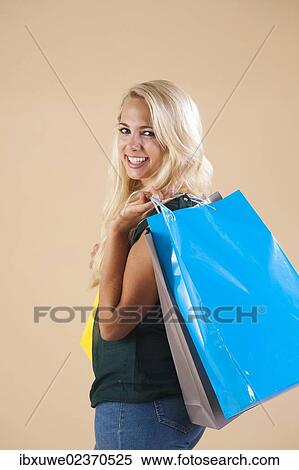 Young woman with shopping bags while shopping View Large Photo Image Stock Photography - Young woman with shopping bags while shopping. Fotosearch