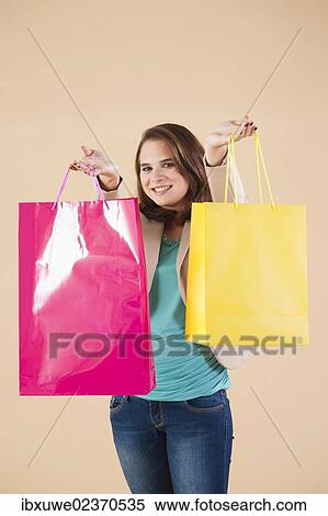 Young woman with shopping bags while shopping View Large Photo Image Stock Photography - Young woman with shopping bags while shopping. Fotosearch