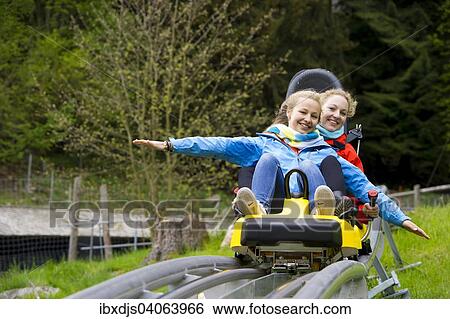Stock Photograph - "Young women on a summer toboggan run, Steinwasenpark in Oberried, Black Forest, Baden-Wurttemberg, Germany, Europe". Fotosearch